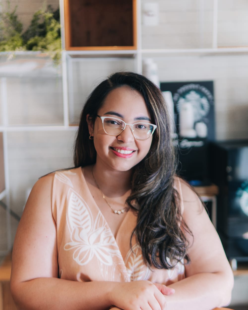 Dra. Luciana Monteiro sorrindo, sentada à mesa